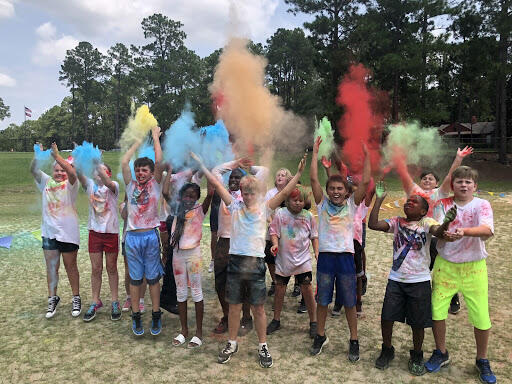 students throwing colored powder in the air